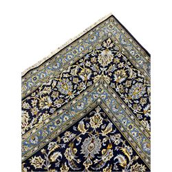Central Persian Kashan indigo ground carpet, central lighter blue floral medallion surrounded by interlacing leafy branches and stylised plant motifs, the main border decorated with repeating floral motifs and scrolling branches, within guard stripes 