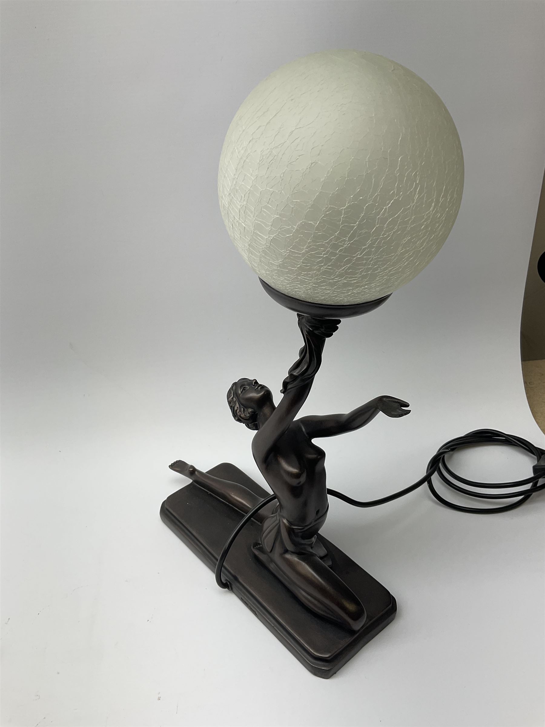 An Art Deco style composite bronze effect table lamp by Crosa, modelled as a semi nude female figure supporting a spherical crackle effect shade in her outstretched hand, overall approximately H47cm.