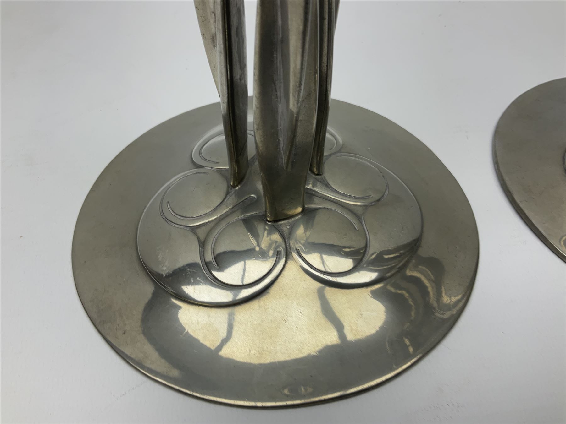 Archibald Knox (1864-1933) for Liberty & Co, pair of Tudric pewter candlesticks, the bud shaped sockets raised upon three angular fin supports and a slightly domed circular base with cast stylised foliate decoration, each stamped beneath Tudric 0223, H30cm