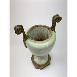 A pate sur pate celadon green vase, of baluster form decorated with a classical female figure to one side, and floral swag with ribbon and musical trophy to the other, with twin gilded scroll handles, and raised upon a gilded base, overall H38.5cm. 