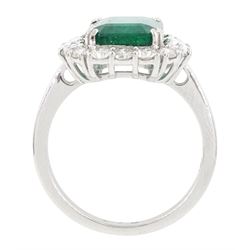 18ct white gold emerald and diamond cluster ring, the octagonal cut emerald of approx 2.85 carat, with an oval cut diamond set either side and round brilliant cut diamond surround, stamped, total diamond weight approx 1.05 carat