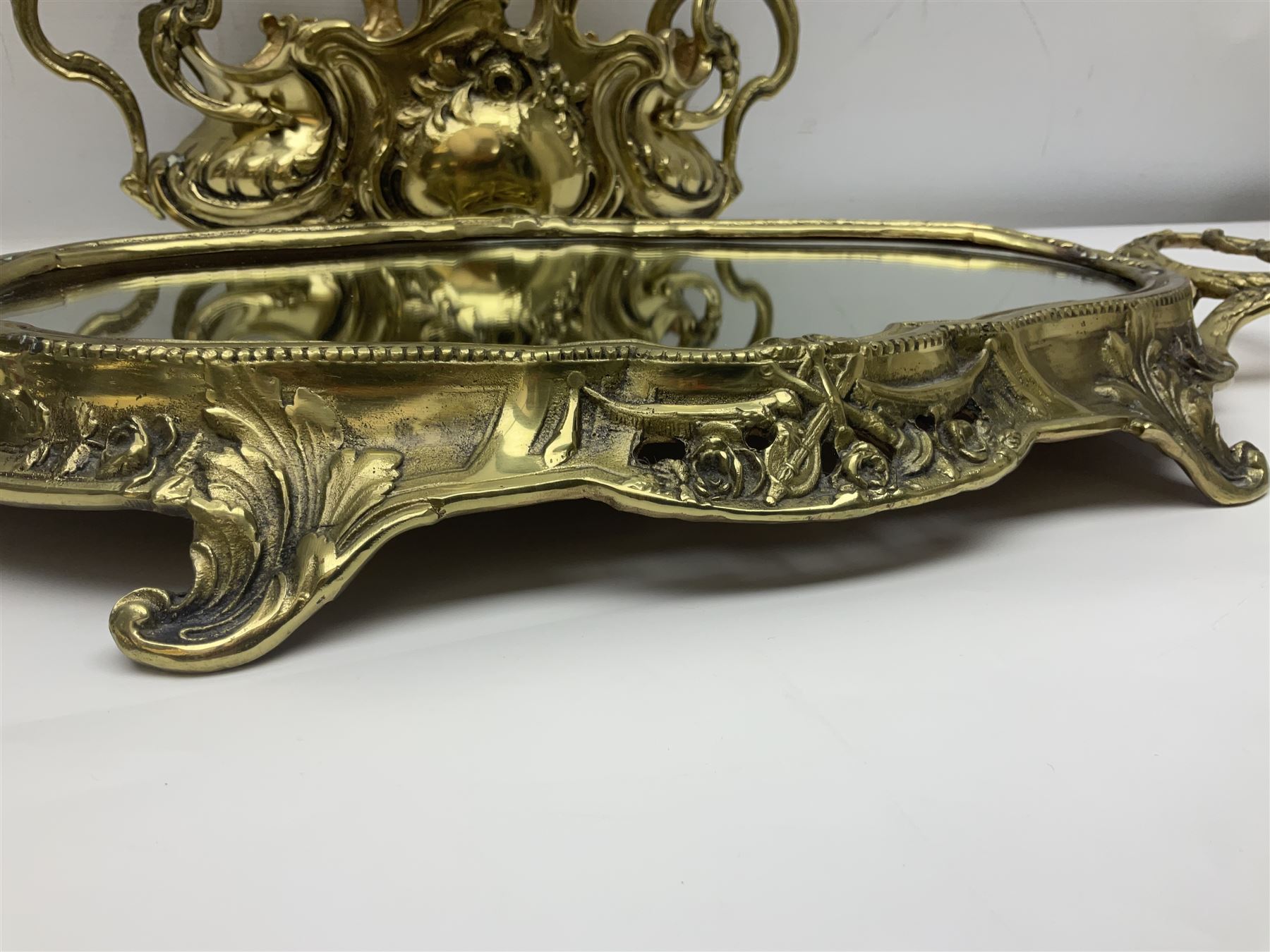 Ornate brass centrepiece, with twin handled vase upon a mirrored base, with floral and scrolling decoration, H23cm 