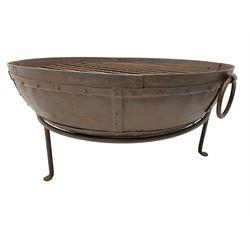 Circular riveted iron fire pit, strapwork sides with twin handles on stand, with grate