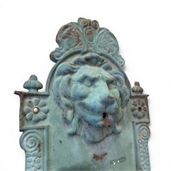 Antique cast iron wall fountain, cartouche cresting rail over a lion mask spout, with scroll and floral decoration over a scalloped basin, in rustic turquoise painted finish with rusted patina