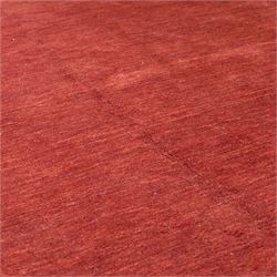 Modern Gabbeh red wool rug, plain madder red field with subtle tonal variation and abrash