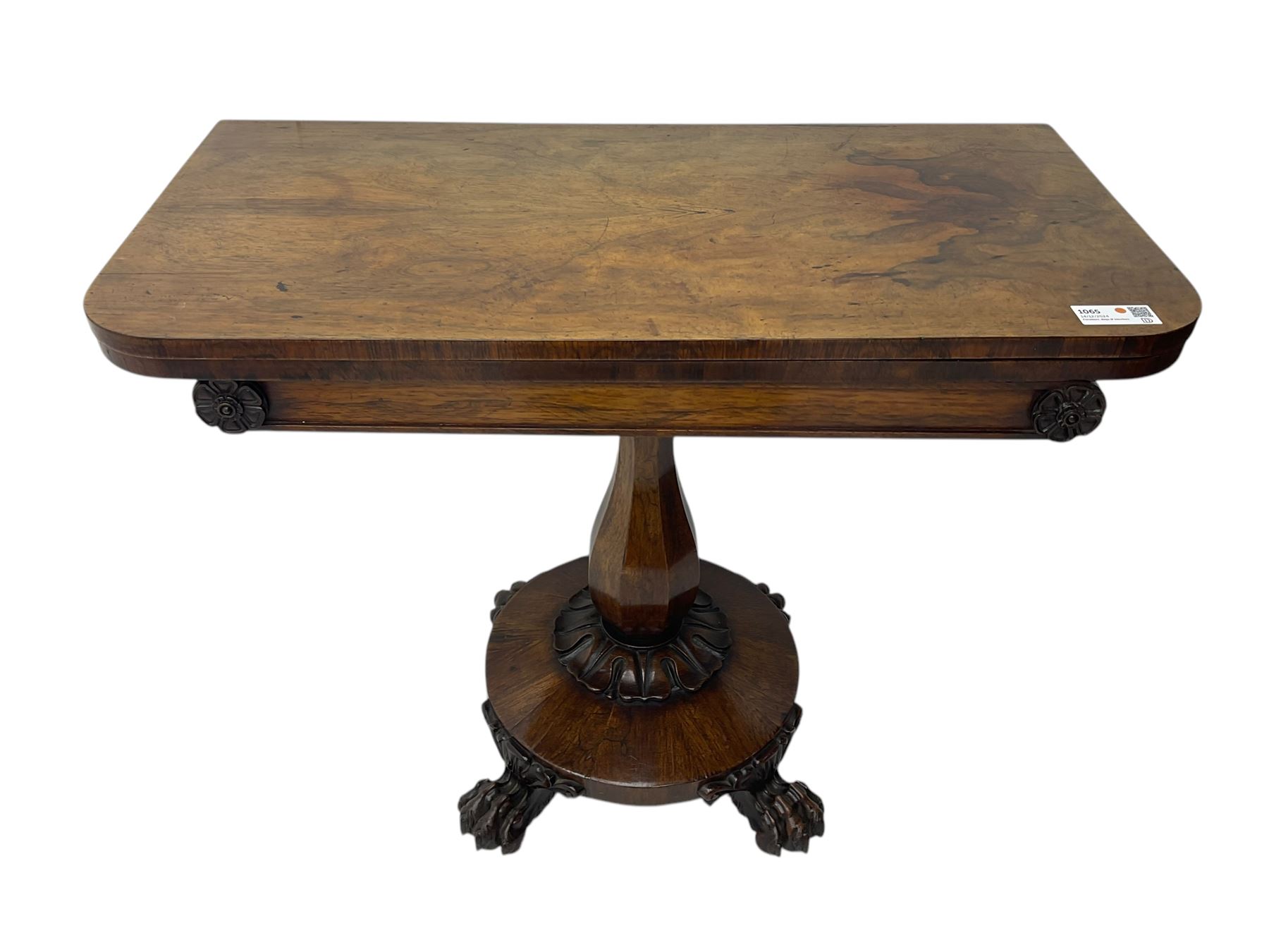Victorian mahogany tea table, rectangular top with rounded corners, folding and swivelling to reveal interior surface, supported on a faceted baluster-shaped column, raised on a circular platform base with carved acanthus details, ending in four lion paw feet