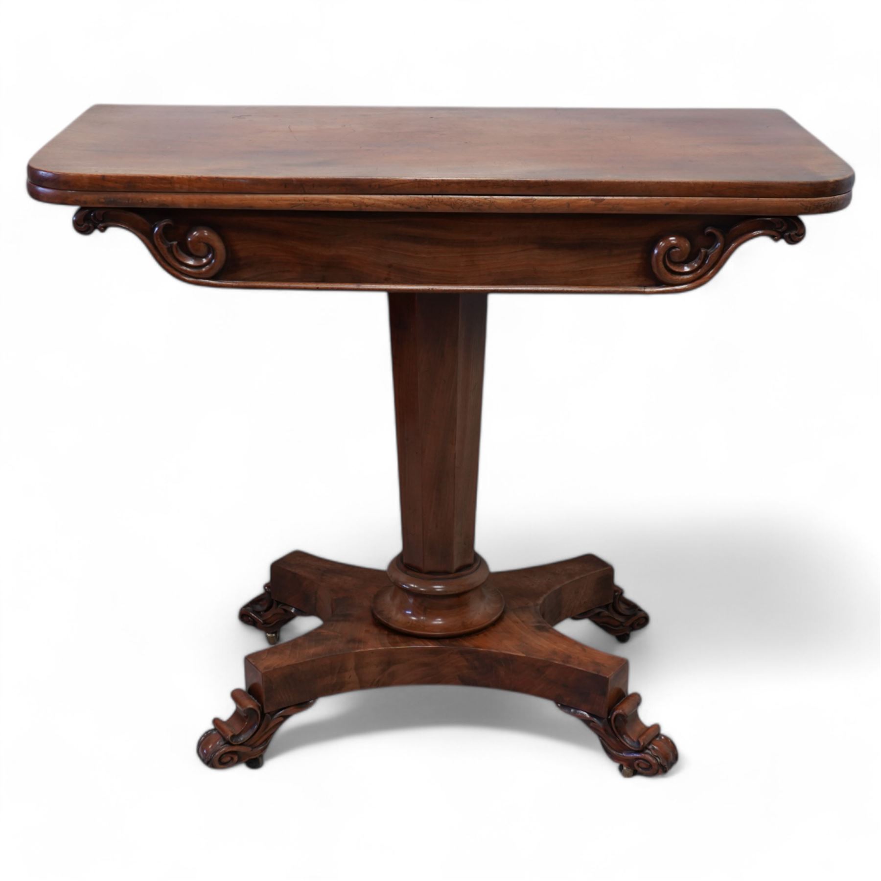 Victorian mahogany tea table, rectangular swivel fold-over top, tapering octagonal column on shaped platform, C-scroll and foliate carved feet with brass castors 