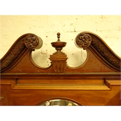  Large Edwardian Adam style mahogany chimney-piece, fire-surround with swan neck pediment and urn finial above circular bevelled mirror plate with two candle branches, enclosed by concave corner cupboards with moulded cornice, blind fret frieze and astragal glazed doors above a quarter veneered panel doors on a skirted base, H340cm, W269cm, D70cm, aperture 107cm x 102cm  