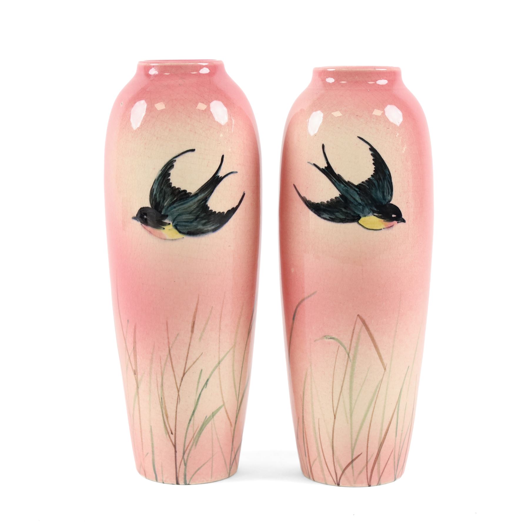 Pair Ault Pottery vases, decorated with swallows in flight upon a pink ground, H22cm