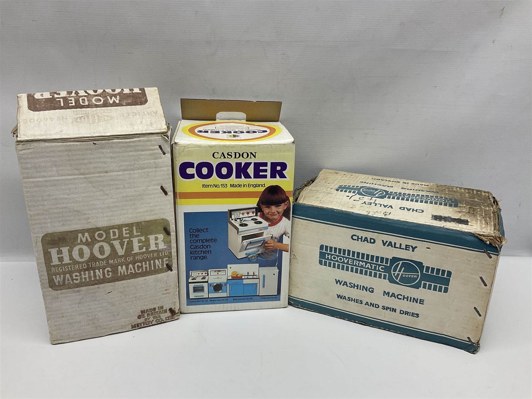 Six toy kitchen appliances - Casdon battery operated cooker; Mettoy Hoover washer; Chad Valley Hoovermatic washer; Wells Brimtoy tin-plate clockwork washer; and two Morphy Richards irons; together with a continental child's Regina sewing machine; all boxed (7)