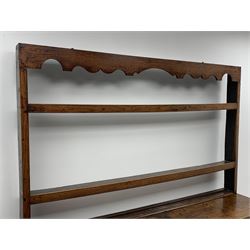 Late 18th century oak dresser, shaped fret work frieze cresting rail over two heights plate rack, the base fitted with four drawers and two cupboards, the central lower drawer is false, stile supports