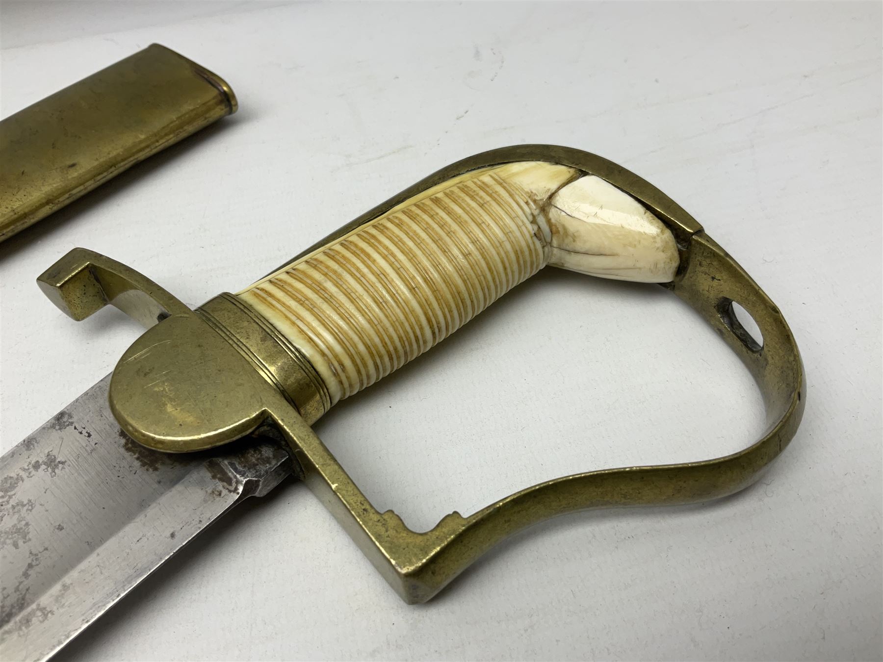 British pattern 1796 Light Cavalry Officer's sword, the 83.5cm curving steel blade marked 'W. Parker London' and 'Warranted' verso, brass stirrup hilt with half-round langets, knucklebow and backstrap with ribbed ivory grip; in brass mounted leather covered scabbard with two suspension rings L97cm overall. This item has been registered for sale under Section 10 of the APHA Ivory Act 
