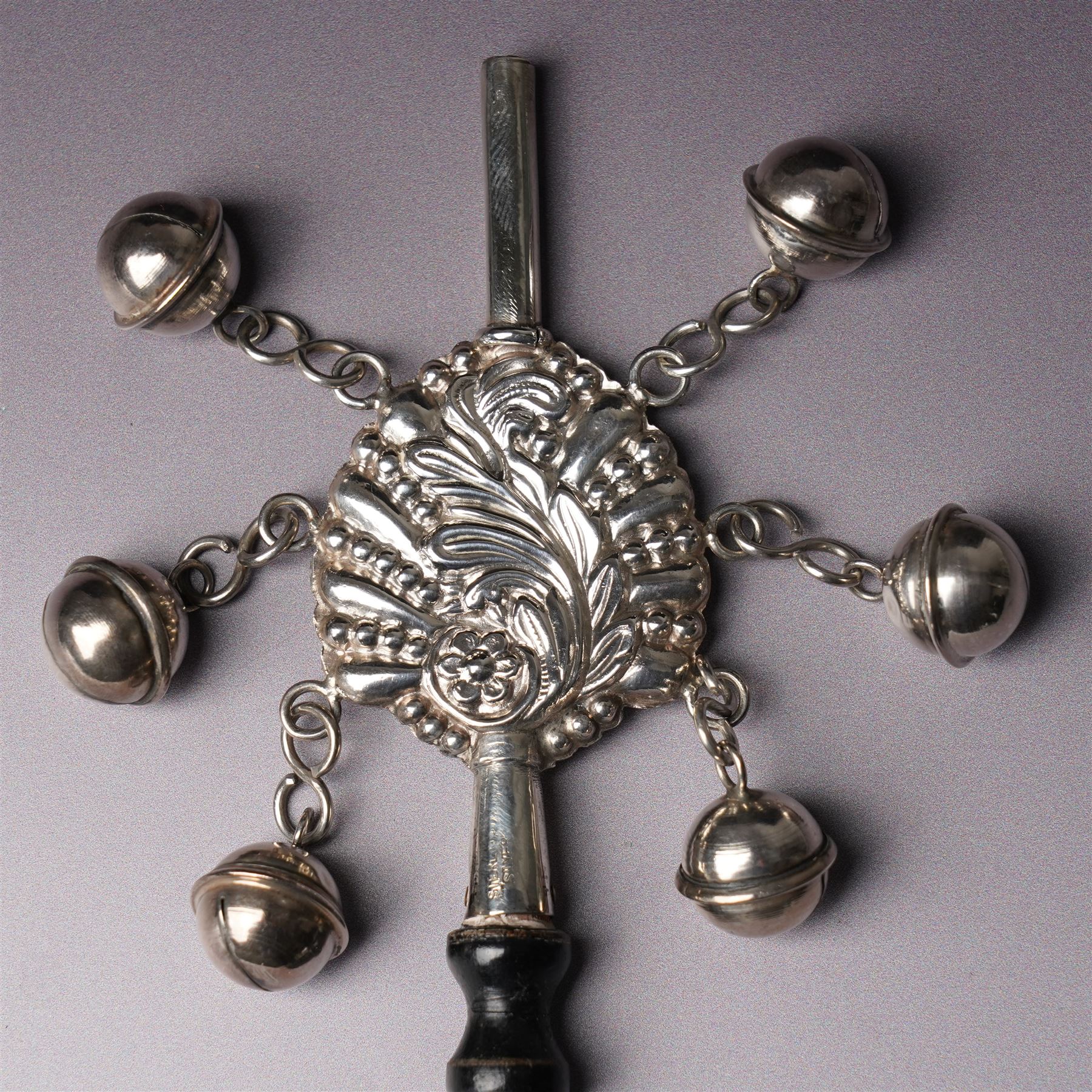 Sterling silver babies rattle with embossed design hung with six bells, whistle and turned wood handle L16.5cm