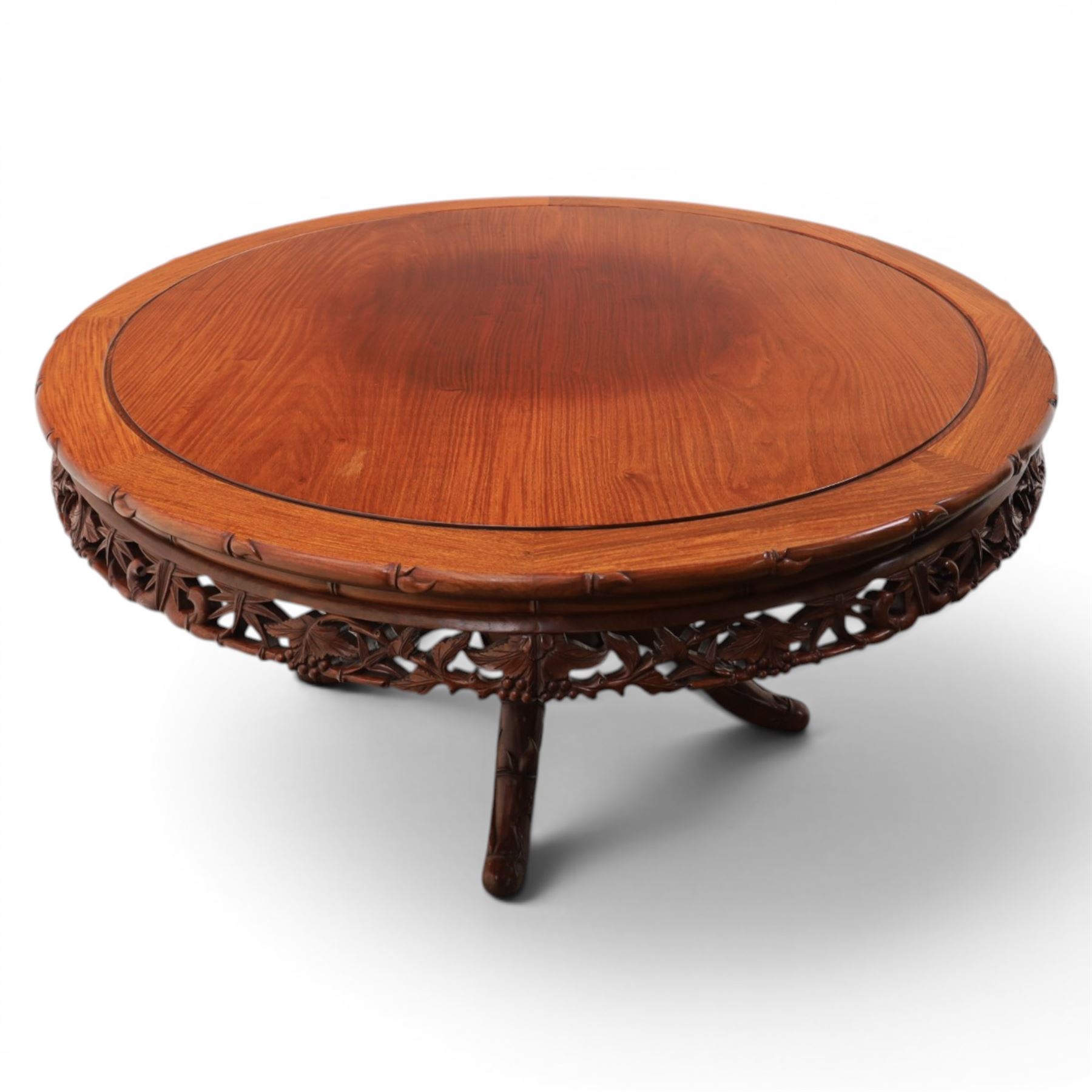 20th century Chinese ornately hardwood dining table and chairs, circular table with 'Lazy Susan' top with pierced carved frieze, raised on a quadriform base with carved foliate detail, the chairs en suite with carved pierced detailing  