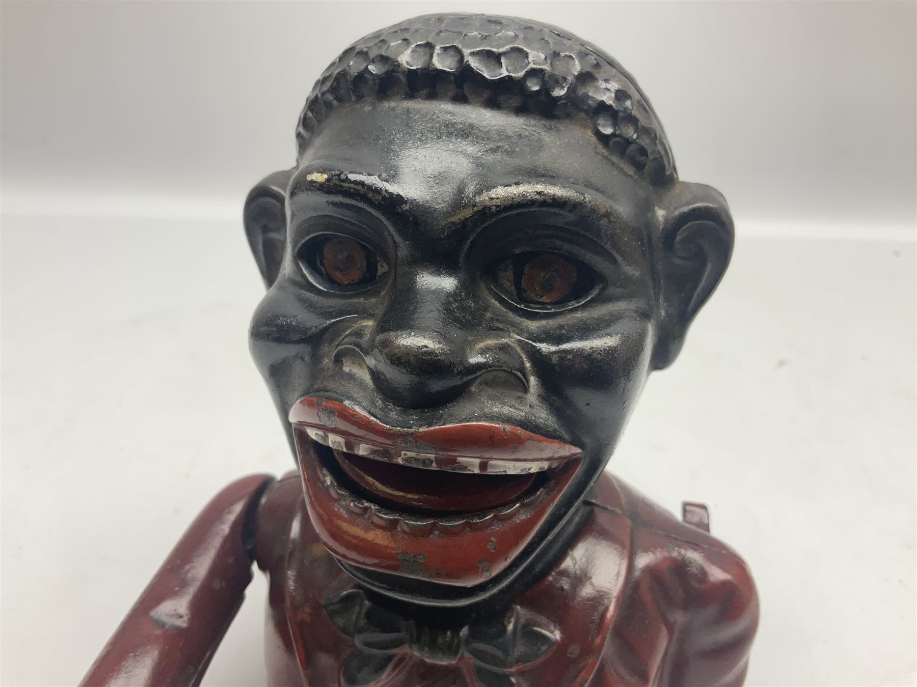 Three early 20th century cast-iron mechanical money banks as a family group comprising mother 'Dinah' patented 1911, father 'Jolly Man' patented 1902 and son 'Little Joe' patented 1910 by John Harper & Co; all with the same hand-to-mouth action; parents H16cm (3)