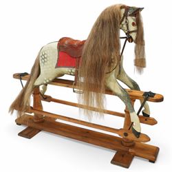 Frederick Henry Ayres (F H Ayres, London) - Late Victorian large carved wooden rocking horse, in dapple grey paint finish, decorated with glass eyes, leather reins, stirrup and saddle, indented hooves, on rockers united by chamfered stretchers and boarded base, c.1890