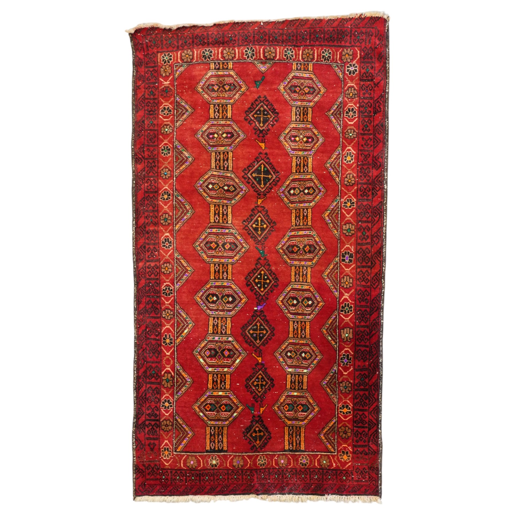 Persian Baluchi crimson ground rug, decorated with three columns of geomtric motifs