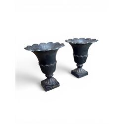 Pair of Victorian large scale cast iron garden urns, flared petal shaped rim with tapering waist, gadrooned base on square plinth, finished in black paint