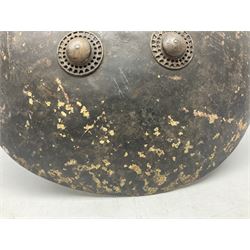 Indian black lacquered hide shield/dhal, of circular convex form fitted at its centre with four pierced iron bosses, each of hemispherical form with wide brims, the bosses corresponding on the inside with four iron rings for enarmes D53.5cm