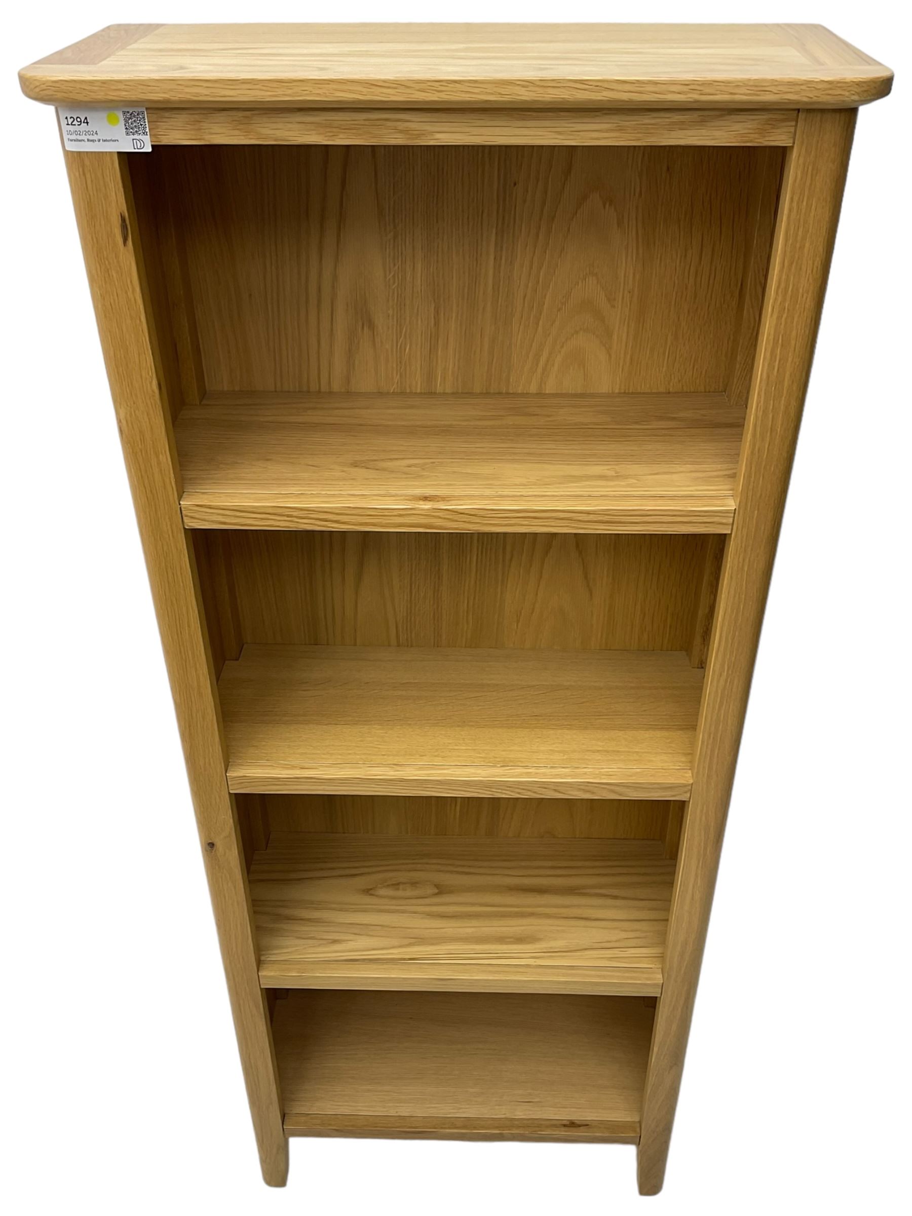 Contemporary light oak open bookcase, fitted with three shelves, on tapering supports