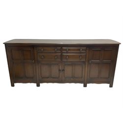 Ercol - dark elm dresser base, fitted with four drawers and four cupboards, enclosed by panelled doors