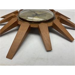 Mid-century teak sunburst wall clock by Anstey & Wilson, modelled with angular teak rays spreading from circular mount with plain brass face with Roman numerals, with battery operated Japanese movement, D45cm