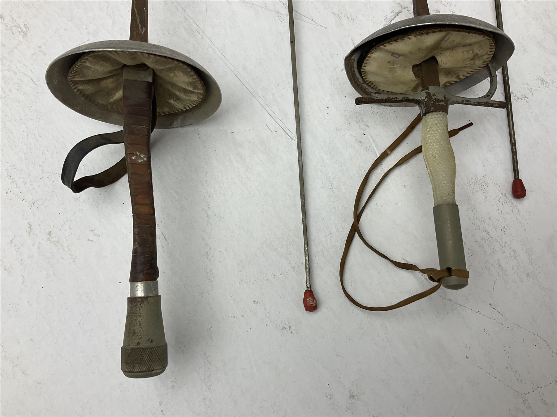 20th century Indian Tulwar sword with 71cm plain curving steel blade and iron hilt with extended langets, knopped grip and spiked pommel; in canvas covered wooden scabbard L87.5cm overall; together with five fencing swords comprising four foils and one epee, three marked Leon Paul, one in carrying case (6)