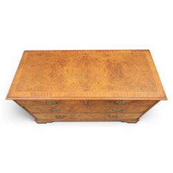 Traditional design walnut inlaid chest, with figured top with circular inlay and crossbanded top with moulded edge, figured drawers with cockbeaded edges and brass handles, raised on bracket feet