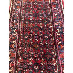 Persian red ground runner, decorated with repeating Heratti motifs, stylised floral guarded border