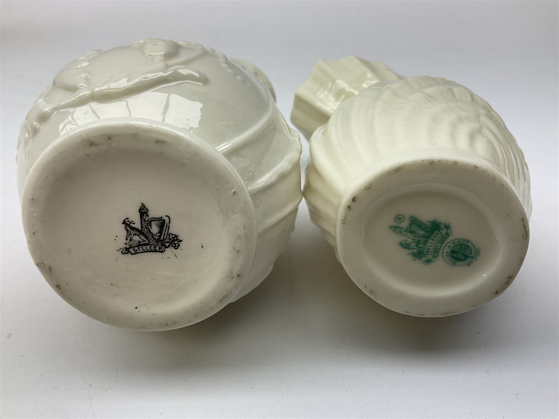 Quantity of Belleek ceramics to include mid-late 19th century jug moulded with green man mask and foliage, date code stamp for 1863-1890, together with later Belleek cornucopia shape vase, jug and other vases together with a Belleek style shell dish raised on branches, tallest H19cm