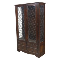 Mid 20th century oak display cabinet, the moulded rectangular cornice above a pair of leaded glazed doors with diamond lattice glazing, enclosing adjustable shelving, the lower section fitted with four short drawers with brass ring handles, flanked by chamfered uprights with carved leaf detail
