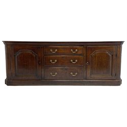 George III oak dresser base, rectangular top with rounded corners over moulded frieze rail, canted corners with turned quarter columns, fitted with three drawers with moulded edges flanked by two cupboards, enclosed by ogee arched fielded panelled doors, panelled sides, moulded plinth base