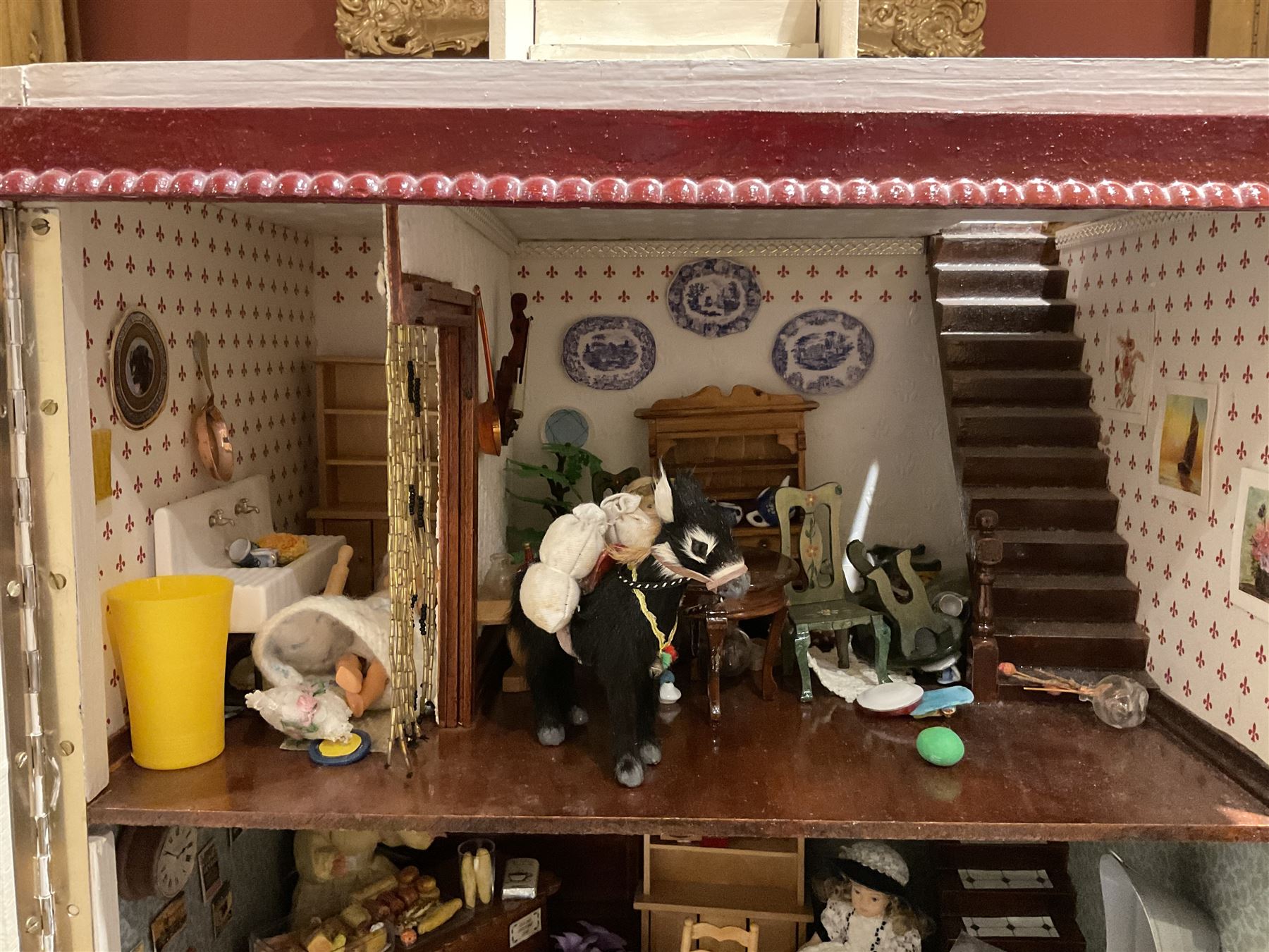 Seagull Pub - scratch-built wooden doll's house as a two-storey gable fronted public house painted in white green and maroon; the hinged front with ground floor veranda and window over opening to reveal two fully furnished rooms with dog-leg staircase and well stocked bar with bar-tender L31cm H62cm D37cm; together with Corner Shop and Dollies Pantry; a similarly painted scratch-built wooden two-storey flat-roofed doll's house as a well stocked ground floor grocery shop with stairs up to two further fully furnished rooms and more stairs giving access to a roof terrace L46cm H57cm D33cm (2)