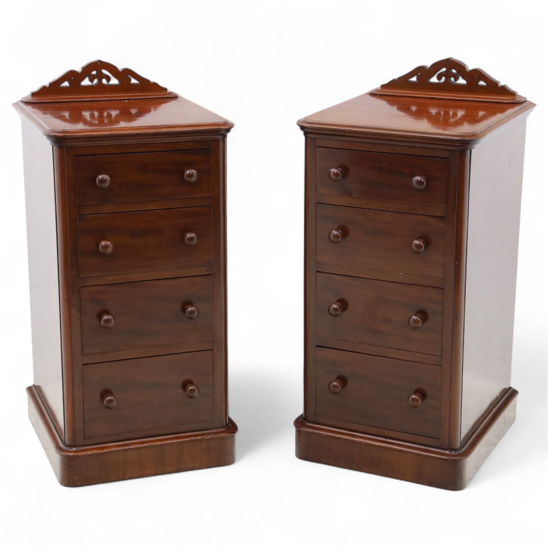 Pair of tall Victorian mahogany bedside chests, of narrow upright form, rectangular top with moulded edge, the back with raised pierced fretwork gallery, above four graduated drawers with knob handles, raised on a plinth base 
