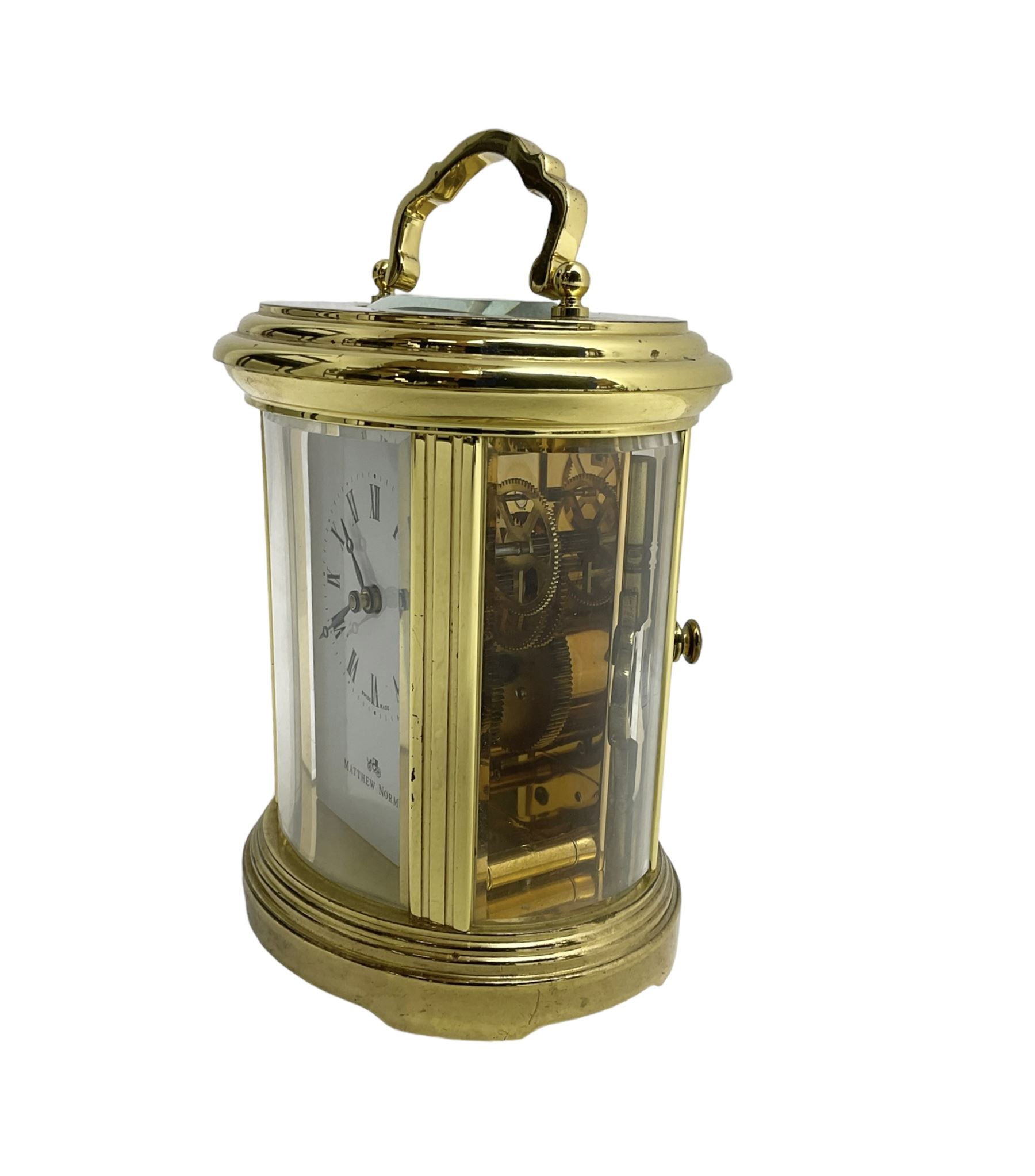 English - 20th century  8-day oval carriage clock, in a polished gilt case with an enamel dial, Roman numerals and moon hands, dial inscribed Mathew Norman, London, timepiece spring driven movement with a lever platform escapement, balance with timing screws. 