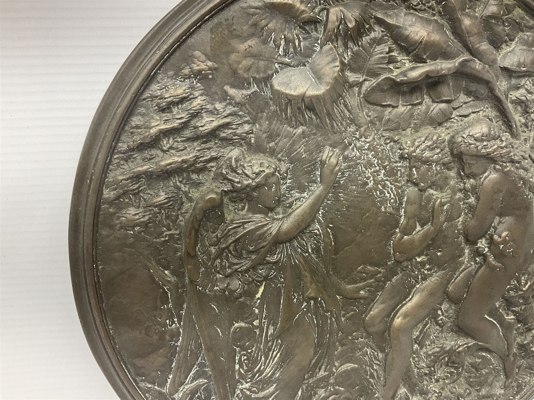 Late 19th century bronze plaque, of circular form, depicting the angel appearing to Adam and Eve in the garden of Eden in high relief, D25.5cm

