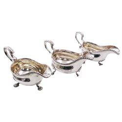 Set of three George III silver sauce boats, each of typical form with gadrooned rim, and acanthus capped scroll handle, upon three shell mounted shell pad feet, one example with engraved crest to body, hallmarked George Methuen, London 1760 including handle H13cm, approximate total weight 44.73 ozt (1391.5 grams)