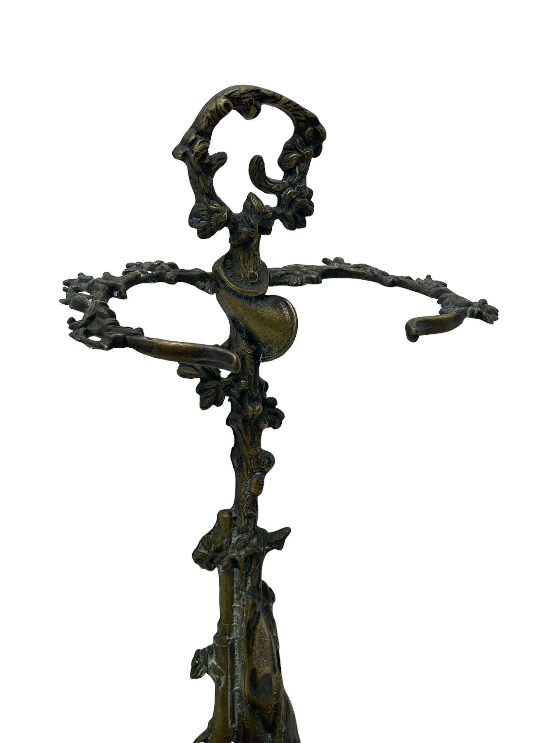 Pair of cast brass hallway umbrella or stick stands, in the form of a tree decorated with trailing flowering foliage branches, the stem with hunting horn over leaning shotgun, shaped naturalist tray base with hunting hound and out splayed foliate cast feet 