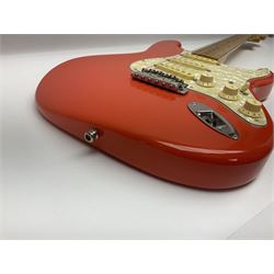 Japanese Squier Fender 'Hank Marvin' Stratocaster electric guitar, c1992, in Fiesta red with tremolo arm and facsimile signature decal; serial no.L037281, L98cm; in hard carrying case.