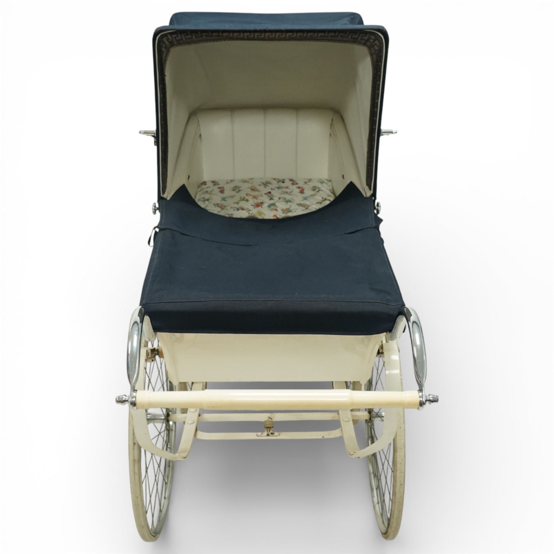 Mid-20th century Osnath pram, the cream painted metal body with navy fabric hood and apron, cream vinyl lined interior fitted with patterned mattress, raised on sprung metal supports with spoked wheels and white rubber tyres