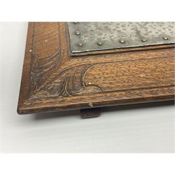 Arts and Crafts oak stand by Arthur Simpson of Kendal, of rectangular form with central hammered pewter panel, surrounded by a border with carved foliate corners, upon two bar supports, bearing label detailed 