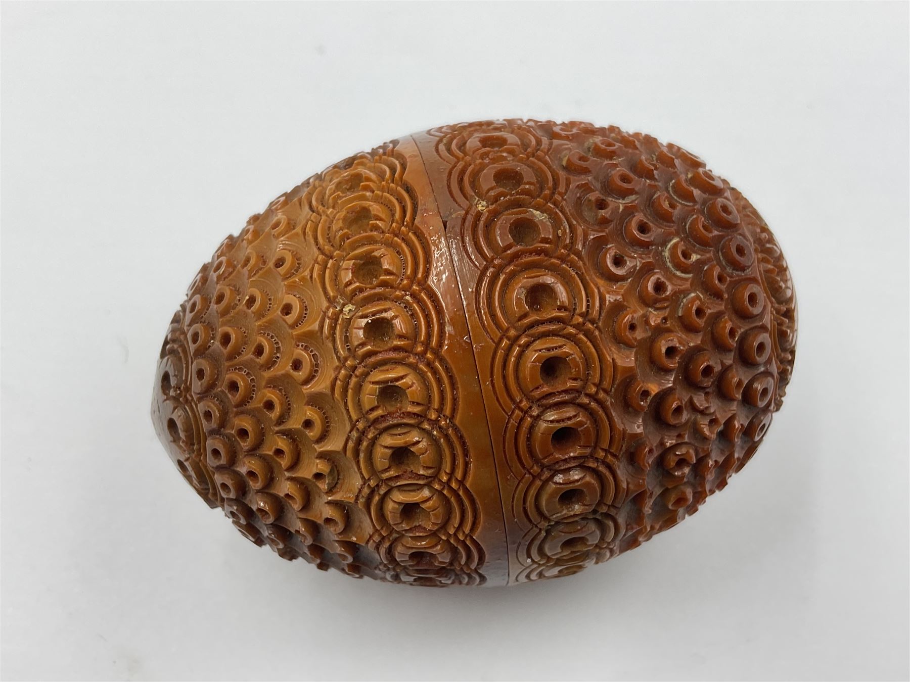Three 19th century coquilla nut pomanders or flea catchers, two of egg shaped form and the third of barrel from with carved and pierced decoration and screw threaded join, largest H8cm