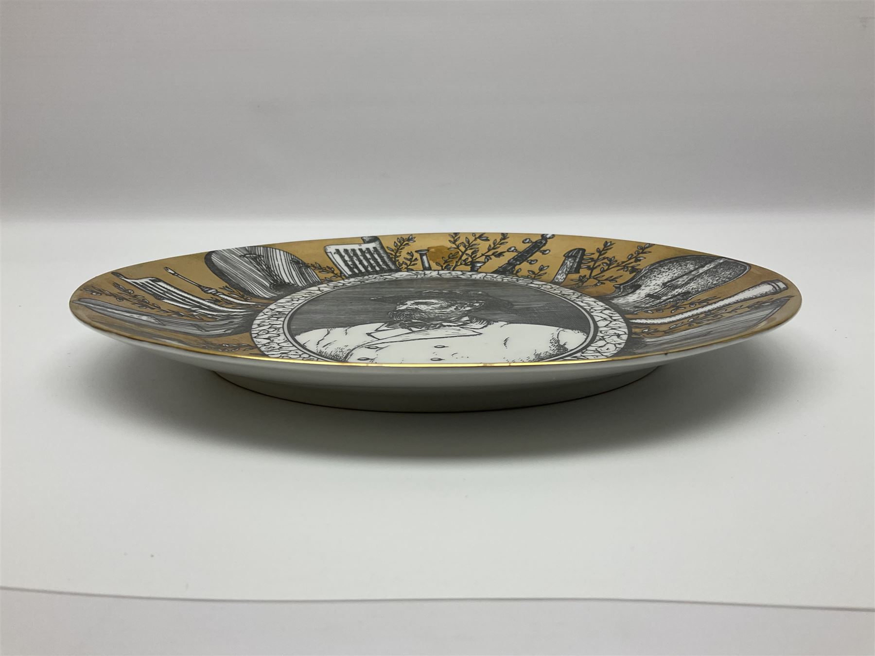 Fornasetti Grandi Maestri plate, depicting Giuseppe Verdi within a border of operatic emblems on gilt ground, with printed mark beneath, D25cm