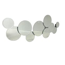 Contemporary abstract circular mirror, comprised of interconnecting bevelled plates of varying sizes