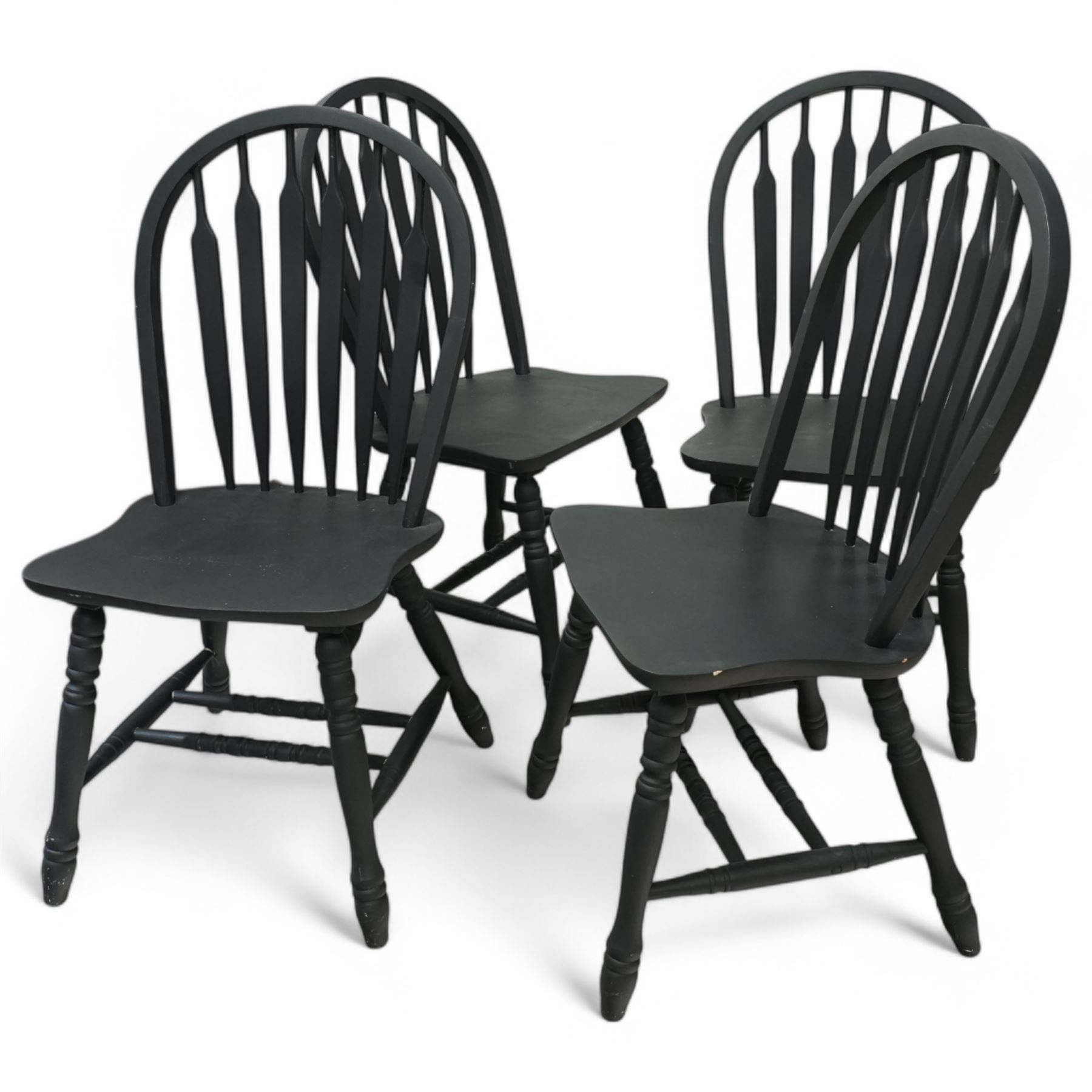 Contemporary country style pine and painted dining table and four chairs, the rectangular plank top with exposed knots and pegged detailing over black painted turned legs, the four Windsor style chairs with shaped seats, spindle splats and turned stretchers, also painted black