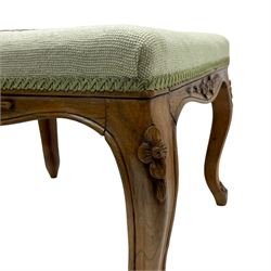 19th century French walnut dressing stool, rectangular seat upholstered in a floral needlework tapestry top, shaped apron with applied carved flower heads, on cabriole supports with acanthus carved feet