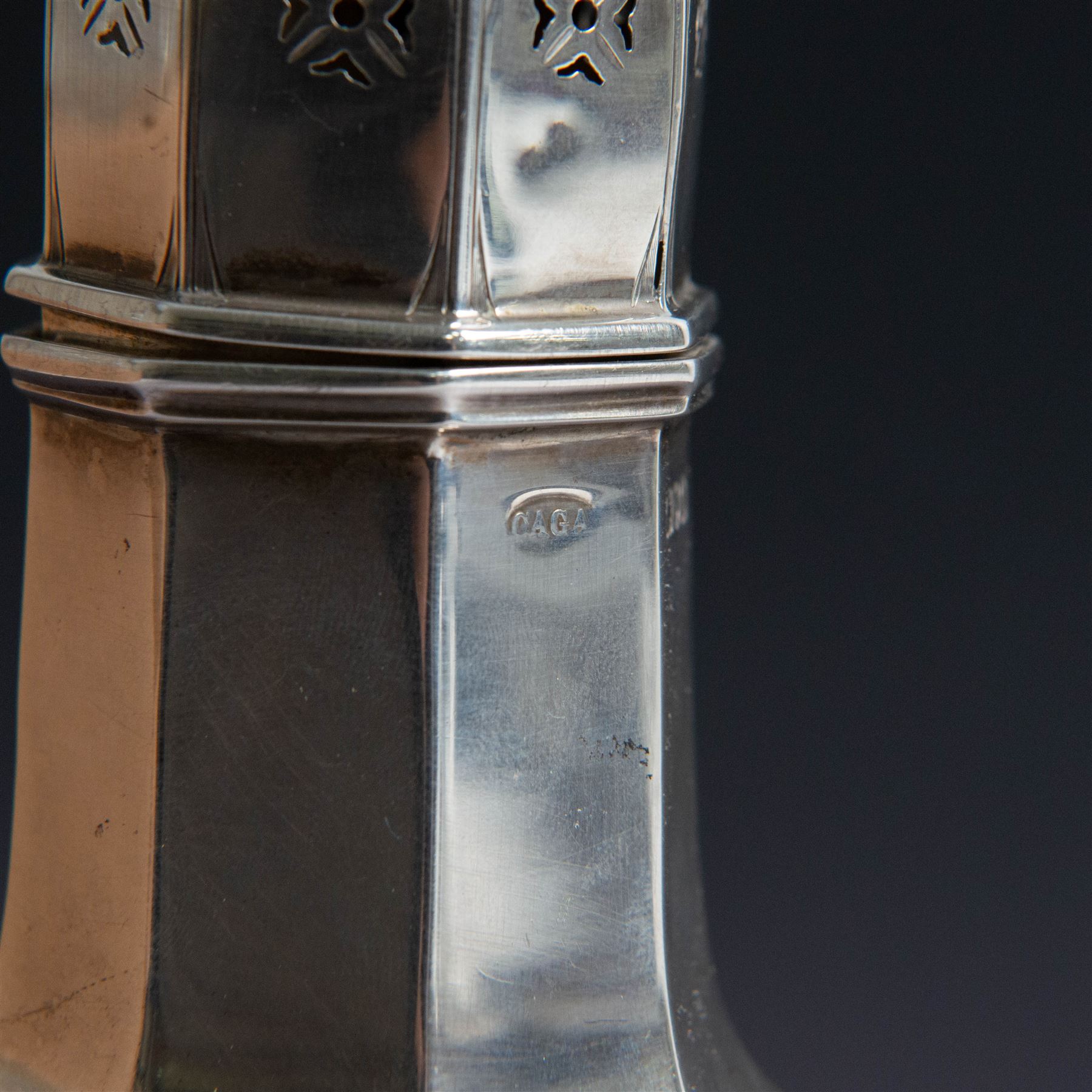 Edwardian silver sugar caster, of octagonal urn form, upon an octagonal foot, the removable pierced cover with urn finial, hallmarked Charles & George Asprey, London 1909, H21cm 