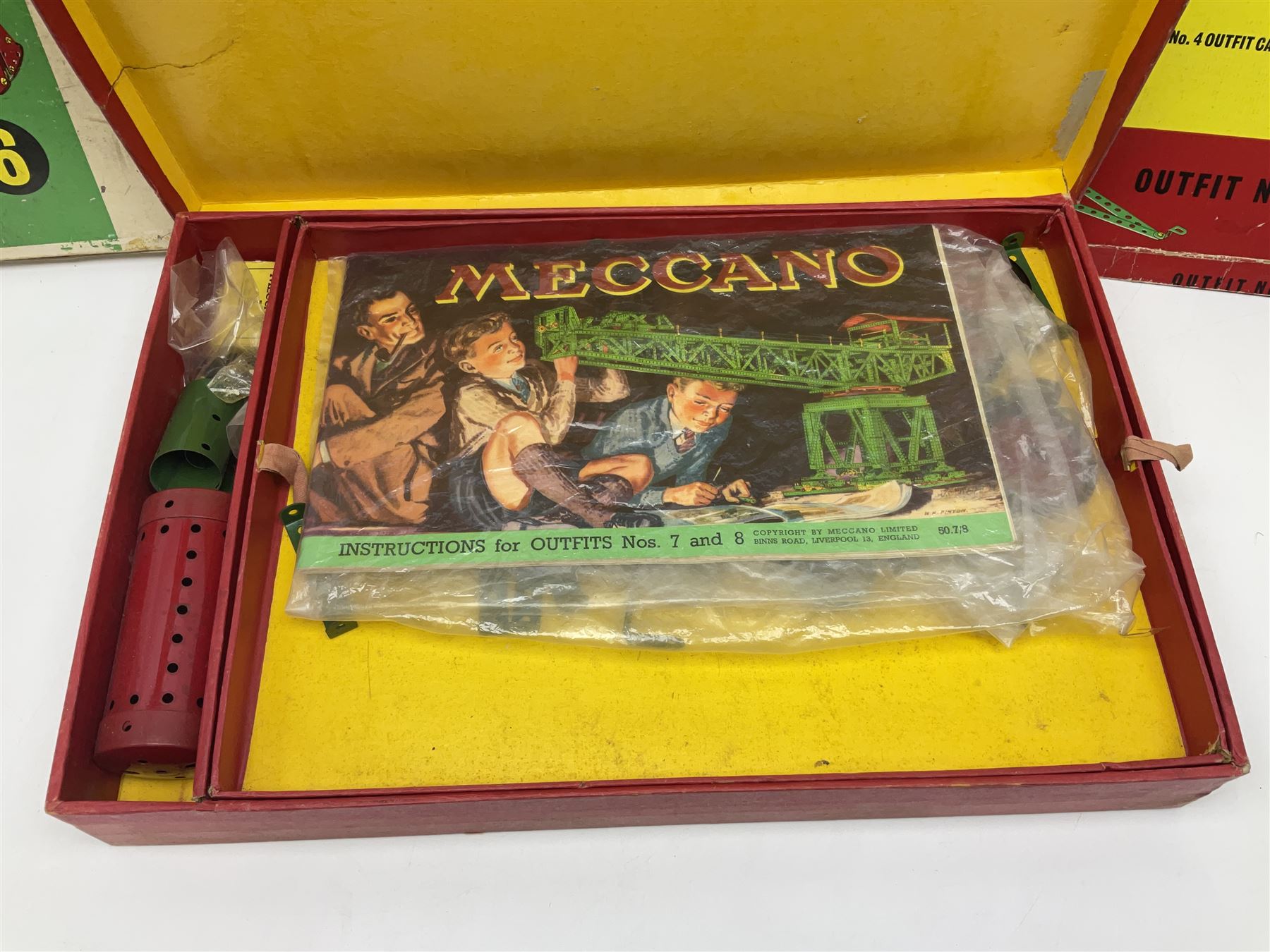 Meccano - Outfits 4, 6 & 7 with red and green parts; Outfits 4 & 6 virtually fully stocked and Outfit 7 containing large quantity of loose parts; Outfits 4 & 7 with instruction manuals; all boxed (3)