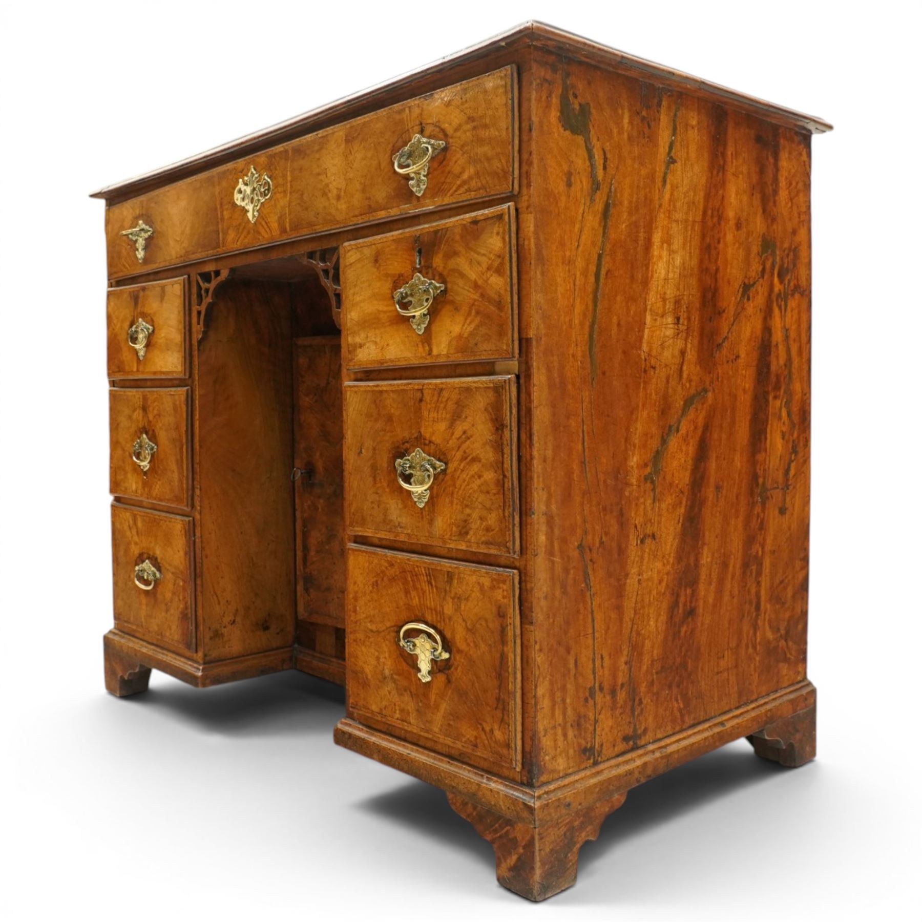 George III figured walnut kneehole desk, the rectangular top with feather and cross-banding with moulded edge, fitted with single frieze drawer over pierced spandrels and recessed cupboard, flanked by six graduating drawers, raised on bracket feet
Provenance: Kirkham Hall