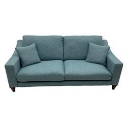 Large two seat sofa upholstered in denim blue fabric, turned dark oak feet, with scatter cushions